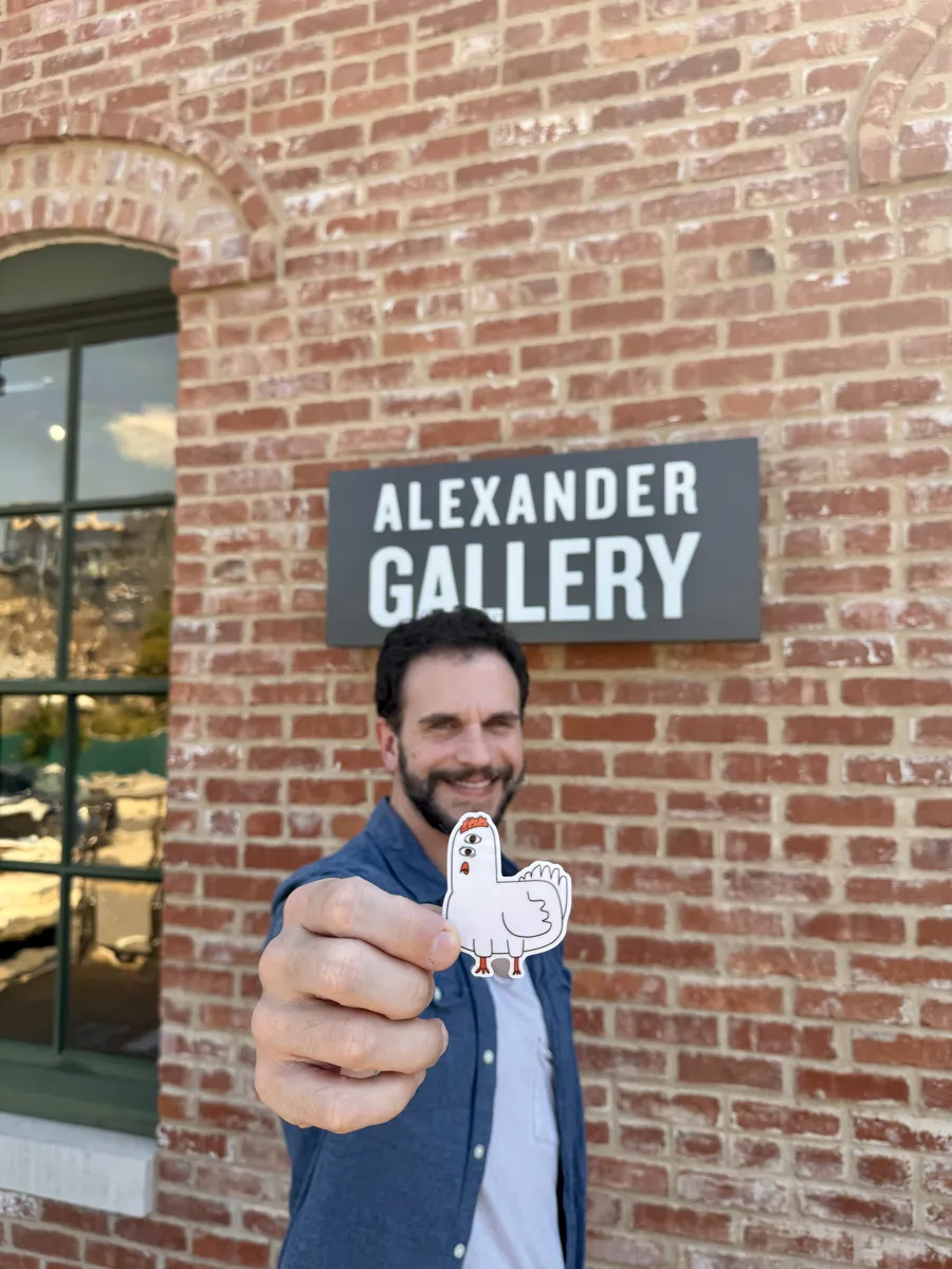 Dylan Yarter with one of his chicken stickers at the Alexander Gallery, 2026.